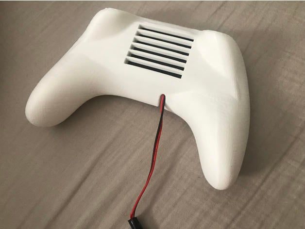 A white controller with a black and red wire
Description automatically generated