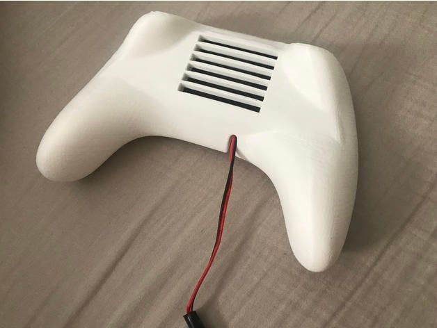 A white controller with a black and red wire

Description automatically generated