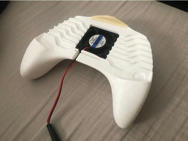 A white game controller with a black wire
Description automatically generated